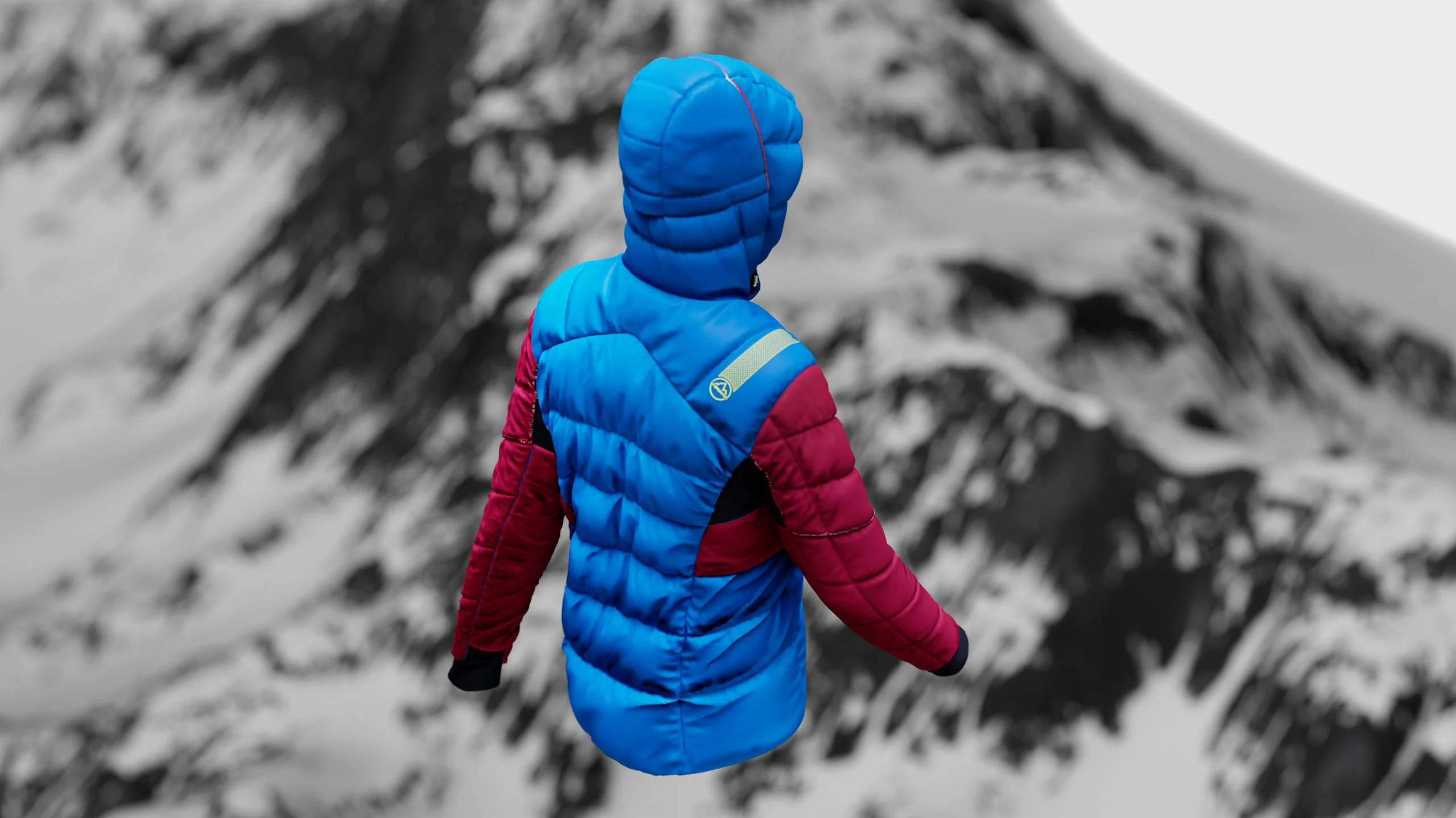 Piumino Alpine Tech azzurro visto di spalle davanti alla montagna
