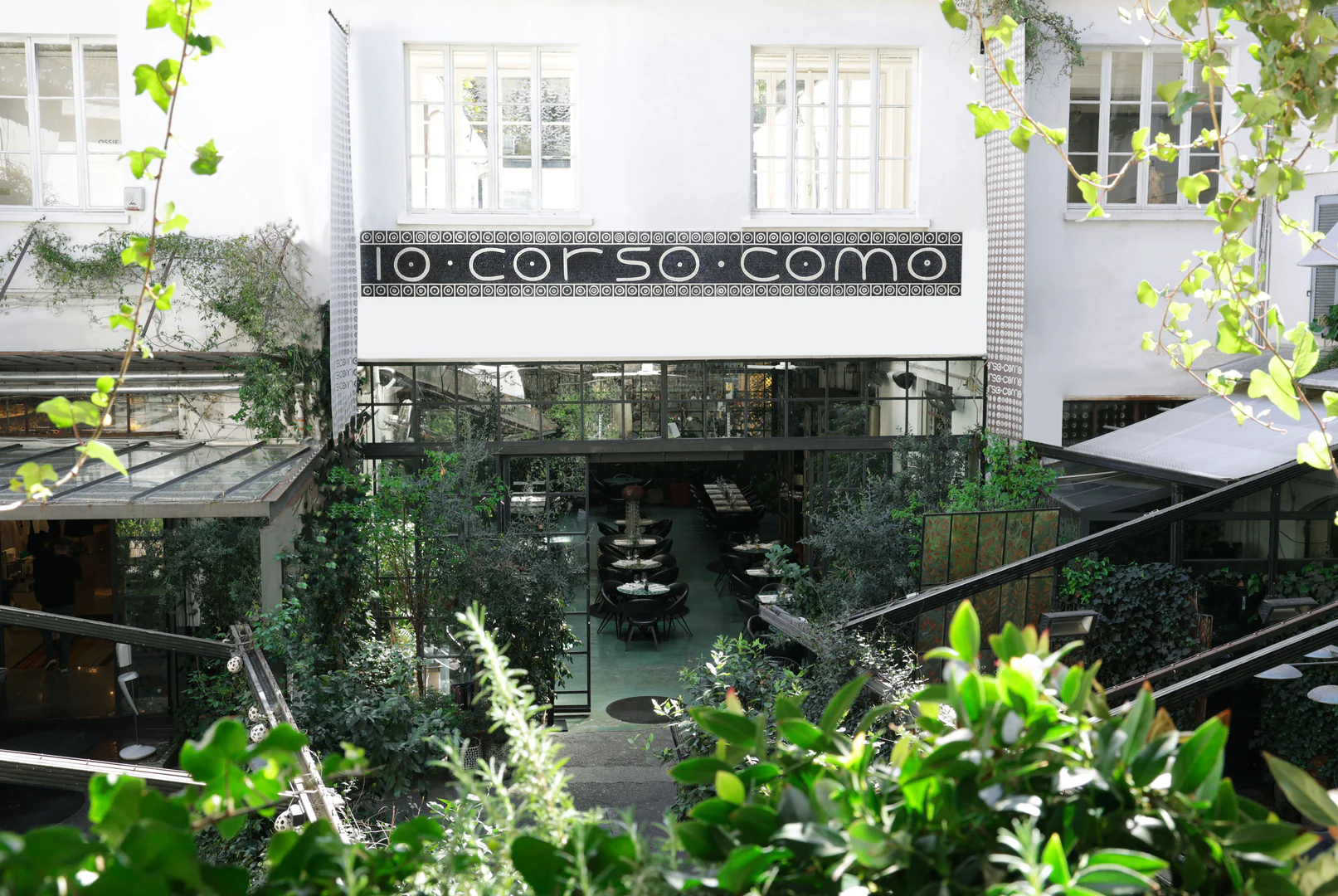 Il cortile di 10 Corso Como con la vegetazione e l'insegna del concept store